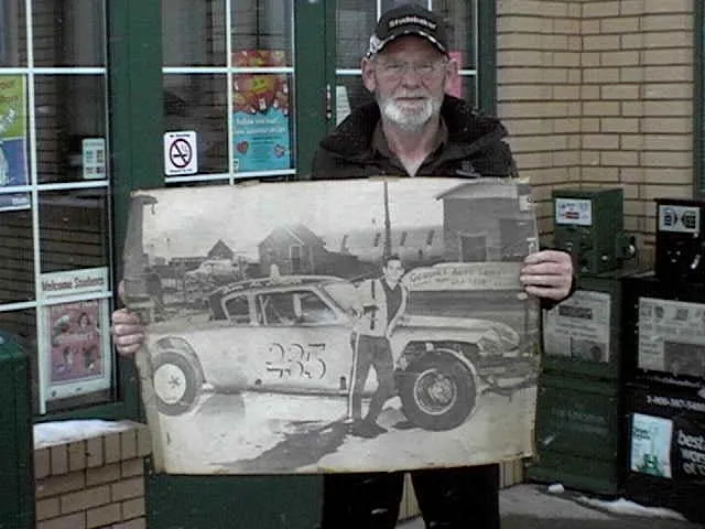 Al showing a poster of him beside his 1953 Studebaker Stock Car he raced in 1969 at Capital City Speedway in Ottawa